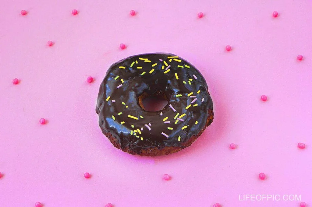 Chocolate Doughnut With Sprinkles on Pink Background - Donuts Images